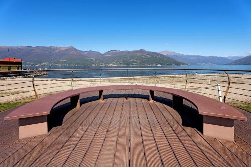 a wooden bench sitting on a pier next to a body of water at Vecchia Scala in Germignaga