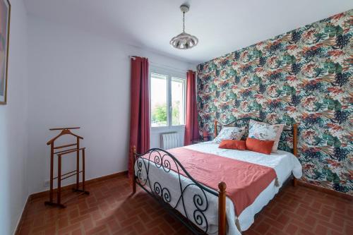 um quarto com uma cama com papel de parede floral em L'Oustau Di paire - Charmante maison pour 6 voyageurs em Châteaurenard