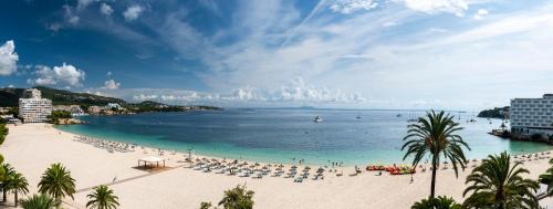 a beach with umbrellas and people on the beach at Zel Mallorca in Palmanova