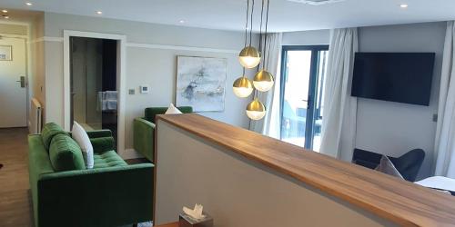 a living room with two green chairs and a table at Beech Hill Hotel & Spa in Windermere
