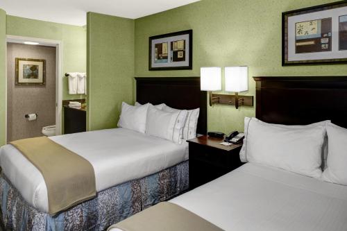 two beds in a hotel room with green walls at Holiday Inn Express Hotel & Suites Atlanta Buckhead, an IHG Hotel in Atlanta