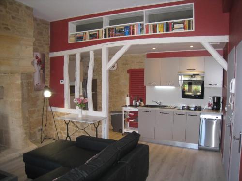 a living room with a couch and a kitchen at PETITS ANGES in Sarlat-la-Canéda