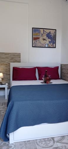 a bedroom with a large bed with red and blue sheets at Angel Room 2 in Nea Plagia