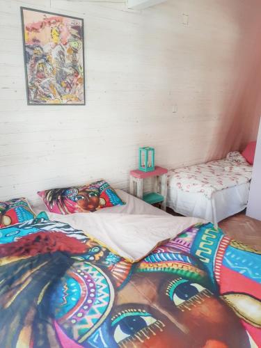 a room with two beds and a painting on the wall at RAINBOW HOME in Gornji Štoj