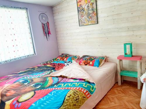 a bed with a colorful comforter in a room at RAINBOW HOME in Gornji Štoj