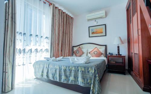 a bedroom with a bed and a window at Silver Mounts Hotel in Phnom Penh