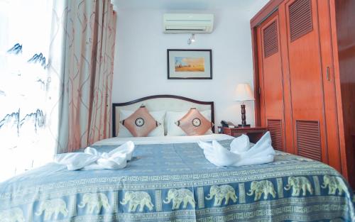 a bedroom with a bed with a blue comforter at Silver Mounts Hotel in Phnom Penh