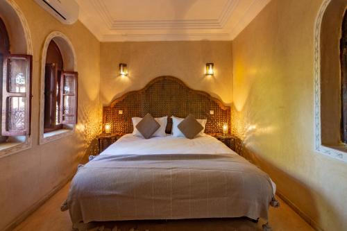 een slaapkamer met een groot bed in een kamer bij Villa Ferme de Coco in El Caïd Omar