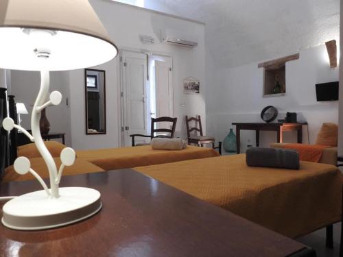 普雷西切的住宿－TRE SORELLE AFFITTA CAMERE，客厅配有两张床和一张带台灯的桌子