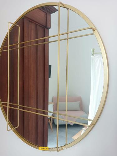 a mirror with a gold frame on a wall at Sapore di Sale - Sicily Rooms in Siracusa