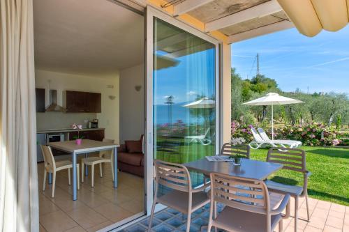 a patio with a table and chairs and a kitchen at La Chioma di Berenice Garda Residence in Toscolano Maderno