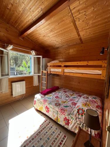 une chambre avec un lit dans une cabane en bois dans l'établissement Chalet*** tout confort à 5 km de la plage, à Bias