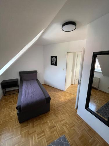 a bedroom with a bed and a mirror and a staircase at TM Apartment in Eibiswald