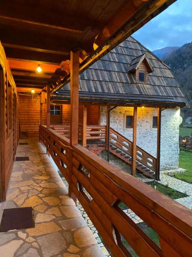 a porch of a wooden house with a fence at Guesthouse Prrockaj Theth in Theth