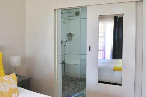 a bathroom with a shower with a glass door at Laguna la Crete 66 in Uvongo Beach