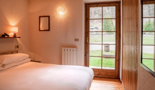 a bedroom with a bed and a window at [Aosta - La Thuile] - Condominio Rolland in La Thuile