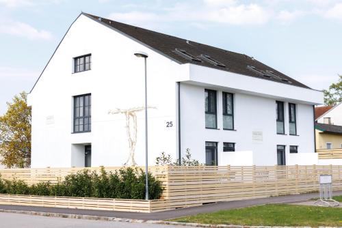 a white house with a wooden fence in front of it at Kracher Hotel Doppelzimmer - für maximal 4 Personen inklusive Pool in Illmitz