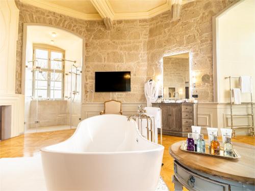 baño grande con bañera y TV en Schloss Frankenberg, en Weigenheim