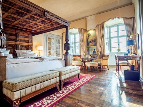 a bedroom with a bed and a table and chairs at Schloss Frankenberg in Weigenheim