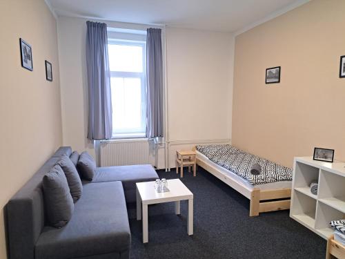 ein Wohnzimmer mit einer Couch und einem Bett in der Unterkunft Pension U Johnů in Petrovice