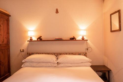 a bedroom with a white bed with two lights on it at [Aosta - La Thuile] - Condominio Rolland in La Thuile