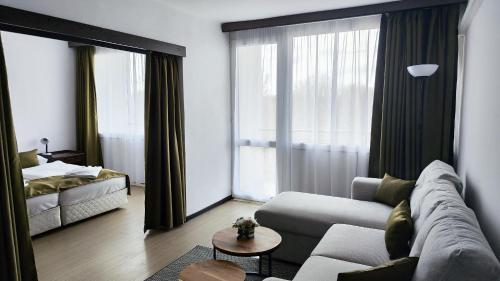 a living room with a couch and a large window at Hotel Európa in Siófok