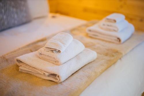 two towels sitting on a cutting board on a bed at Amethyst Apartment in Oxford