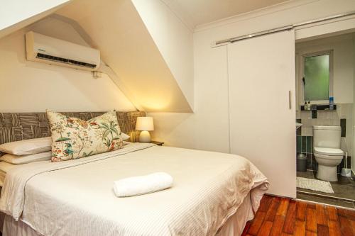 ein Schlafzimmer mit einem Bett und ein Badezimmer mit einem WC in der Unterkunft Shelbourne Lodge in Durban
