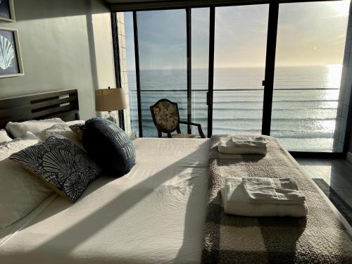 Ocean View Luxury Condo Oceanfront and Pool في سان دييغو: غرفة نوم مع سرير وإطلالة على المحيط