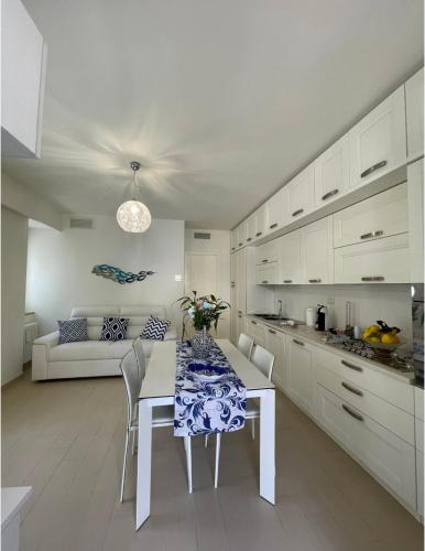 a white kitchen with a table and a couch at L'albero della vita in Minori