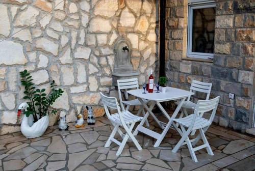 a white table and chairs on a stone patio at APARTMANI DIJANA in Trebinje