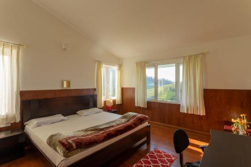 a bedroom with a large bed with a large window at lynfields leisure in Ooty