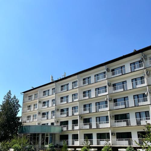un immeuble d'appartements avec un ciel bleu en arrière-plan dans l'établissement TOURIST HOTEL, à Chimkent