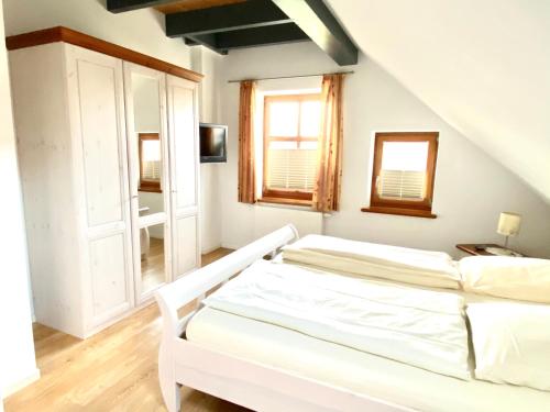 une chambre blanche avec un lit et une fenêtre dans l'établissement Bummert am Hafen 3 Greetsiel, à Krummhörn