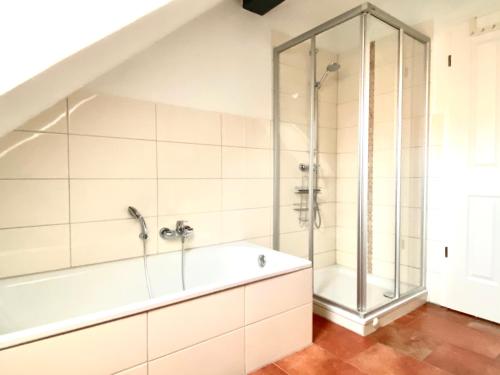 La salle de bains est pourvue d'une douche et d'une baignoire. dans l'établissement Bummert am Hafen 3 Greetsiel, à Krummhörn