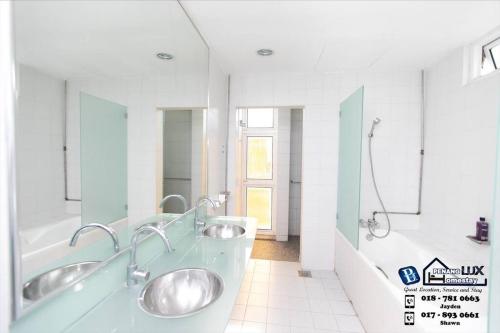 Baño blanco con 2 lavabos y bañera en GeorgeTown 6BR KTV Bungalow 28Pax, en George Town