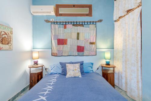 フォンターネ・ビアンケにあるL'impronta di Thalassoのベッドルーム1室(青いベッド1台、ランプ2つ付)