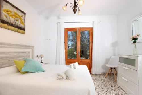 a white bedroom with a bed and a window at Villa La Vinya Can Oliver - Oliver in Pollença