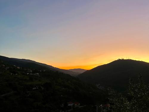 a sunset over the mountains with the sun setting at Private Douro- Quinta das Susandas in Mesão Frio