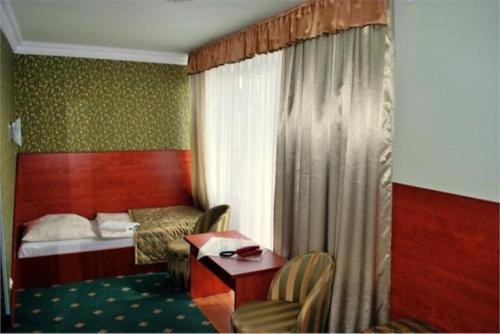 ポランチクにあるPrzystań Caryńska w Polańczykuのベッド、テーブル、椅子が備わるホテルルームです。