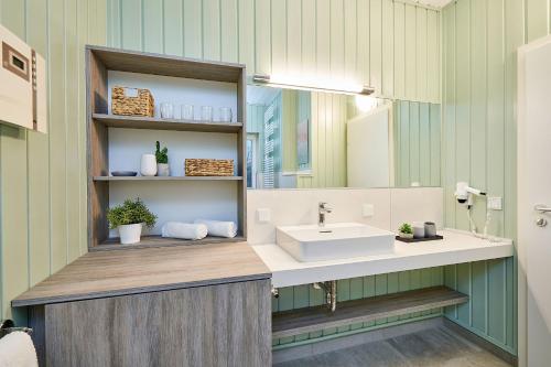 ein Bad mit einem Waschbecken und einem Spiegel in der Unterkunft Typ F "Holger Ehlers" -Kapitänshaus- in Pelzerhaken