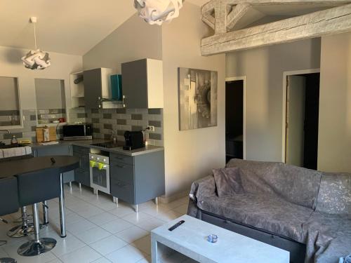 uma sala de estar com um sofá e uma cozinha em gorges du Verdon et lacs chambre indépendante réfrigérateur,plancha extérieure pas de cuisine parking gratuit em Régusse