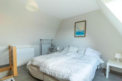 ein weißes Schlafzimmer mit einem Bett und einer Lampe in der Unterkunft Mondial 0201 in Middelkerke