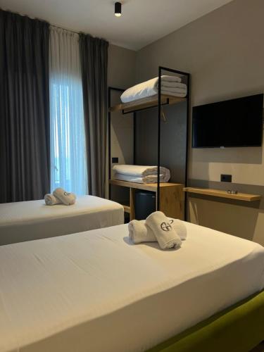 a hotel room with two beds and a flat screen tv at Gogo's Boutique Hotel in Dhërmi