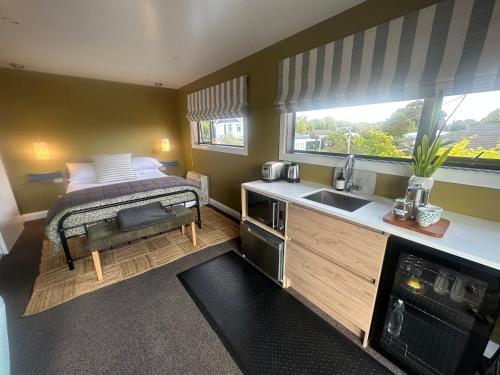Dormitorio pequeño con cama y lavamanos en Beckenham Studio on tree lined street, en Christchurch