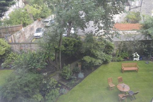 uma vista aérea de um jardim com uma mesa e bancos em Beautiful Home In Stockbridge Edinburgh em Edimburgo