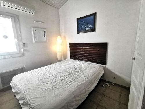 une chambre avec un lit blanc et une fenêtre dans l'établissement 5100 Mas de la Pinède 210, au Cap d'Agde