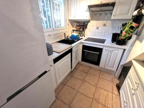 une petite cuisine avec des armoires blanches et un évier dans l'établissement 5100 Mas de la Pinède 210, au Cap d'Agde