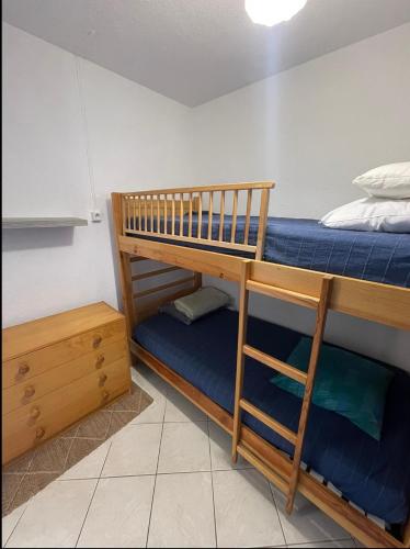 - une chambre avec 2 lits superposés et des draps bleus dans l'établissement Charmant appartement à quelques mètres de la plage, à La Londe-les-Maures