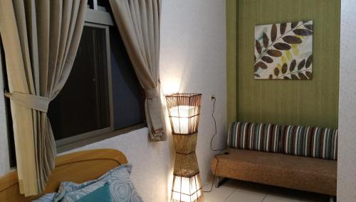 a lamp in a room with a bed and a window at Song Lin Homestay in Dongshan